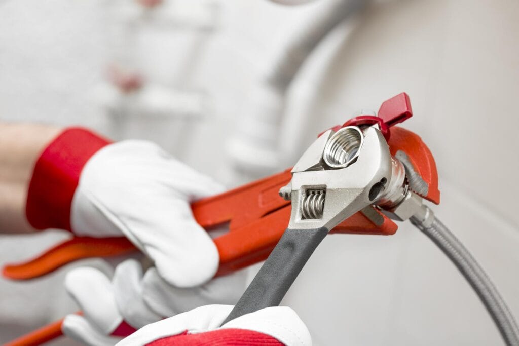 Plumber holding pipe wrenches for an emergency repair in Palm City