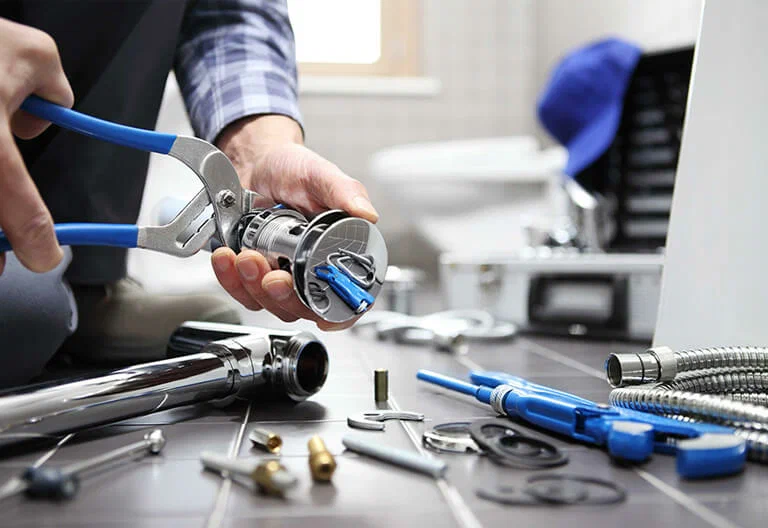 Technician repairing a plumbing fixture with professional tools in Palm City