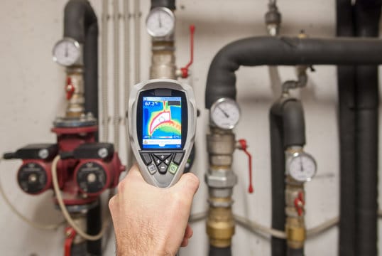 Plumber using a thermal imaging camera to inspect pipes in Palm City