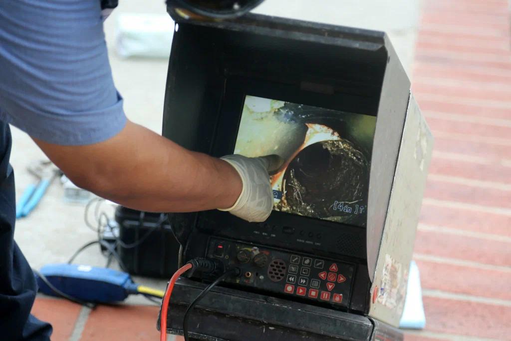 Technician viewing a drain inspection camera in Palm City