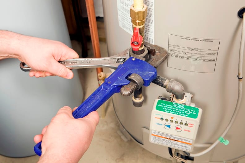 Plumber repairing a water heater valve in Palm City